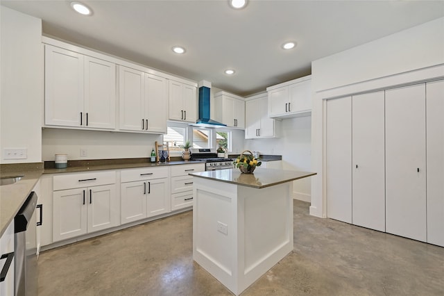 kitchen featuring stainless steel appliances, wall chimney range hood, concrete floors, white cabinetry, and recessed lighting