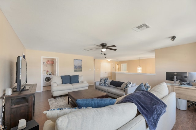 living room featuring washer / clothes dryer, dark hardwood / wood-style floors, and ceiling fan