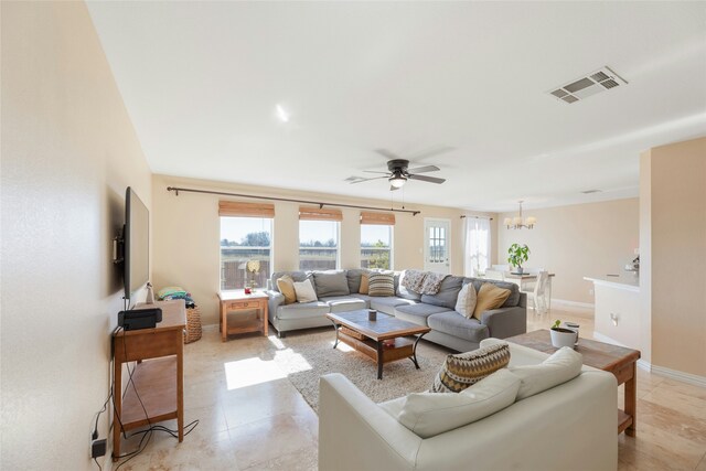 living room featuring ceiling fan with notable chandelier and a healthy amount of sunlight