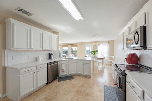 kitchen with sink, appliances with stainless steel finishes, white cabinetry, backsplash, and kitchen peninsula