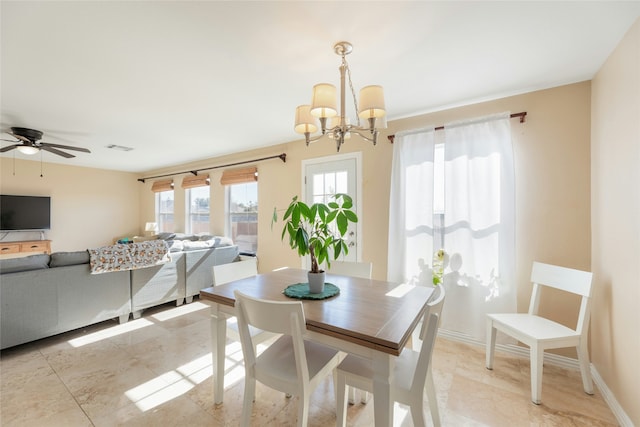 dining area featuring ceiling fan with notable chandelier