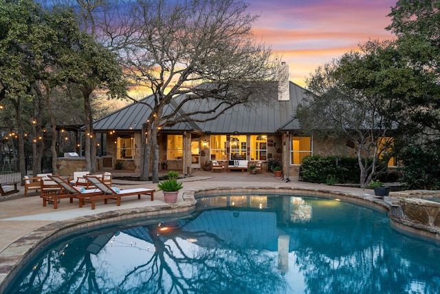 pool at dusk with a patio