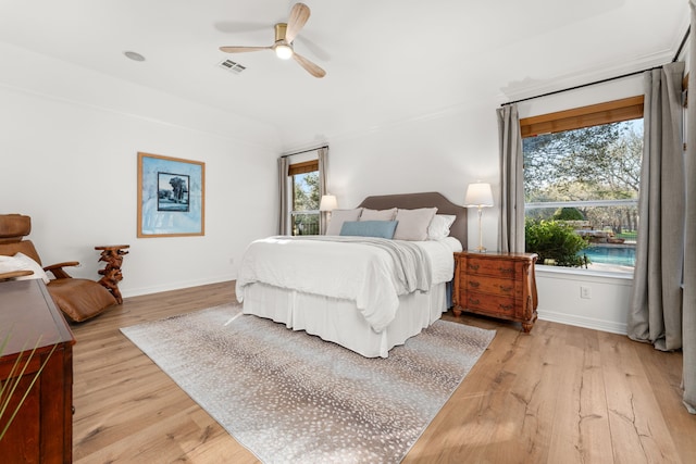 bedroom featuring multiple windows, light hardwood / wood-style flooring, and ceiling fan