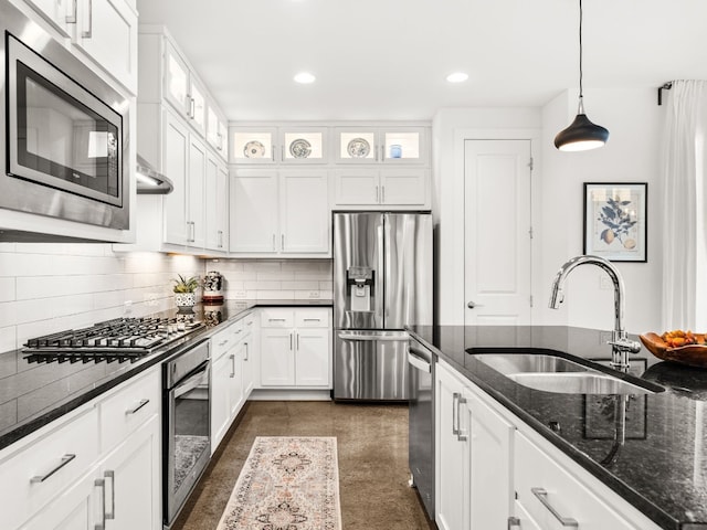 3711 Garden Villa Ln Unit A, Austin, TX 78704 - kitchen featuring stainless steel appliances, white cabinets, decorative backsplash, dark stone counters, and glass insert cabinets