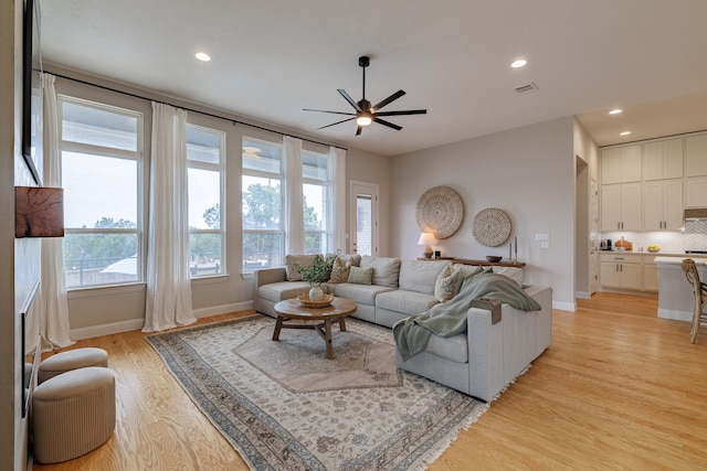 living room with ceiling fan and light wood-type flooring