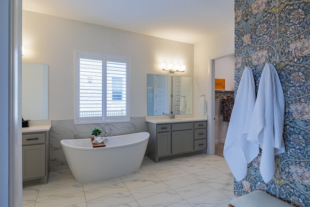 bathroom featuring vanity, a tub, and tile walls