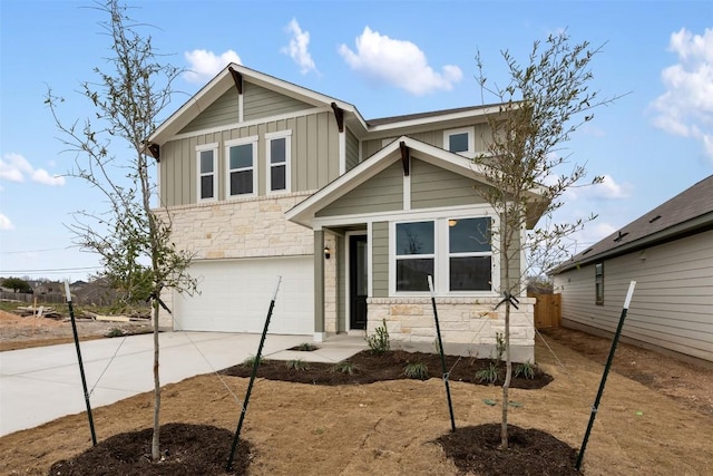 view of front of home with board and batten siding, stone siding, driveway, and a garage