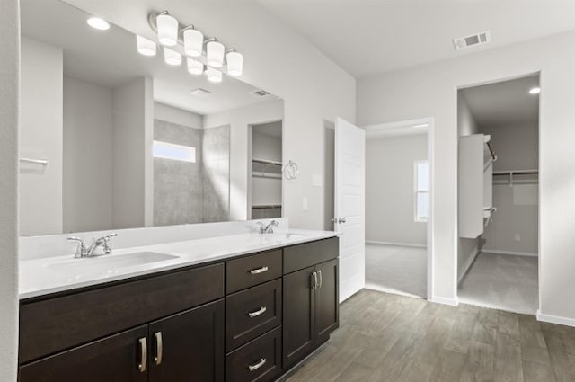 bathroom with wood-type flooring, vanity, and a shower