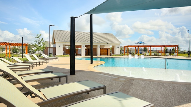 view of swimming pool with pool water feature, a pergola, and a patio area