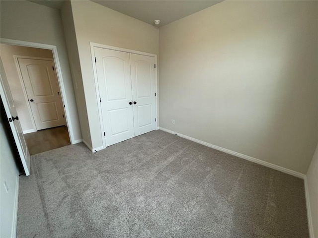 unfurnished bedroom featuring light colored carpet and a closet