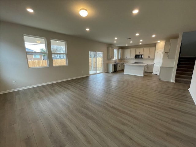 unfurnished living room with dark hardwood / wood-style flooring and sink