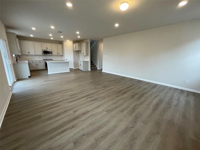 unfurnished living room with dark hardwood / wood-style floors and sink