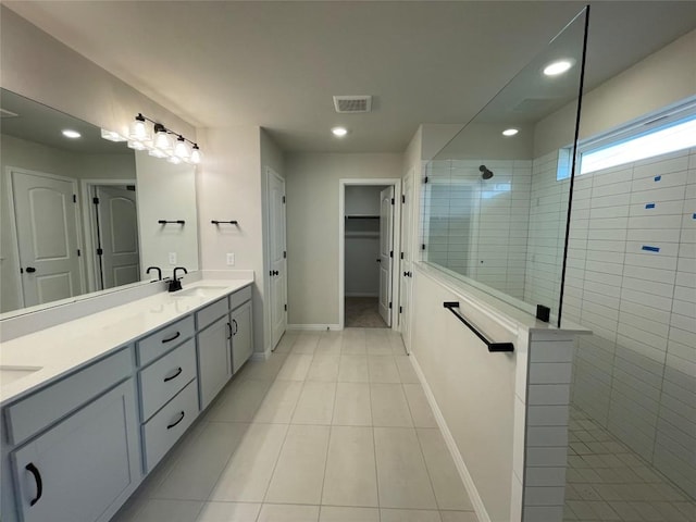 bathroom with vanity, tiled shower, and tile patterned floors