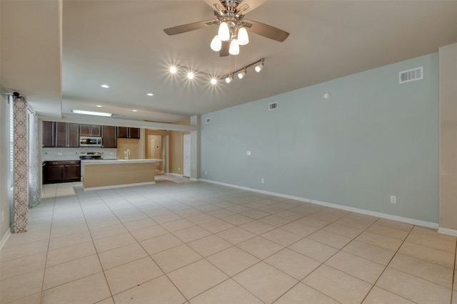 unfurnished living room with ceiling fan and light tile patterned floors