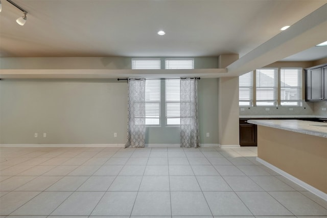 interior space featuring dark brown cabinets, light tile patterned floors, and backsplash