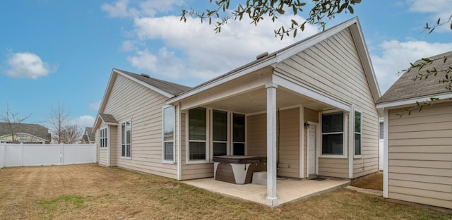 back of house with a patio and a lawn