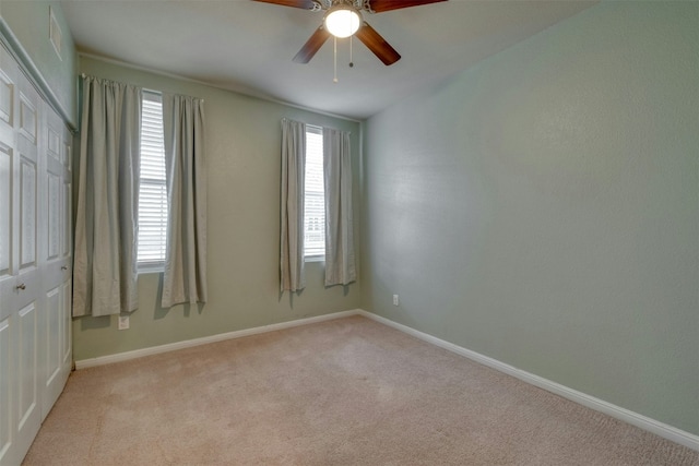 carpeted spare room featuring ceiling fan and a healthy amount of sunlight