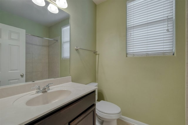 bathroom featuring tiled shower, vanity, and toilet