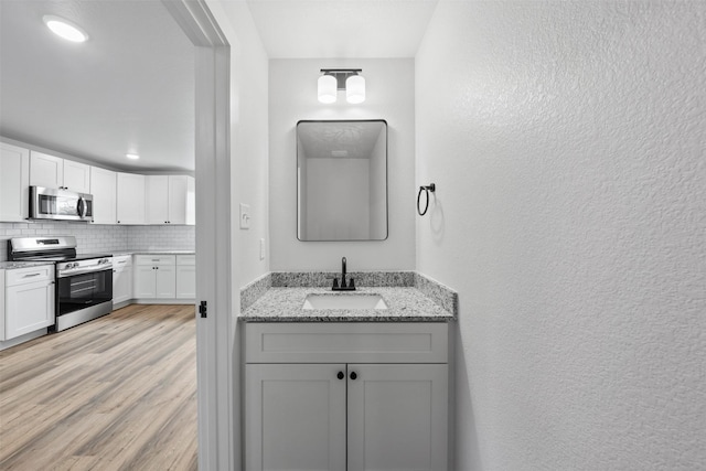 bathroom with tasteful backsplash, sink, and wood-type flooring