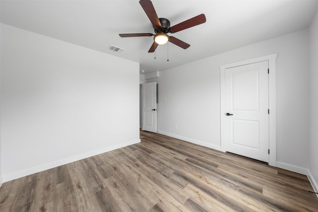 empty room featuring ceiling fan and hardwood / wood-style floors