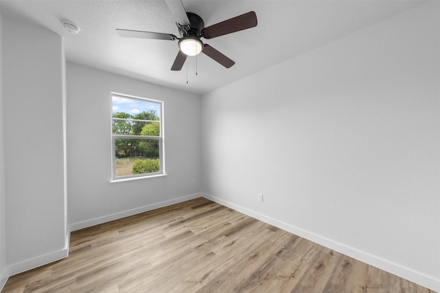 spare room with ceiling fan and light wood-type flooring