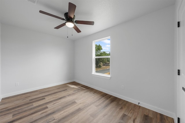 spare room with ceiling fan and light wood-type flooring