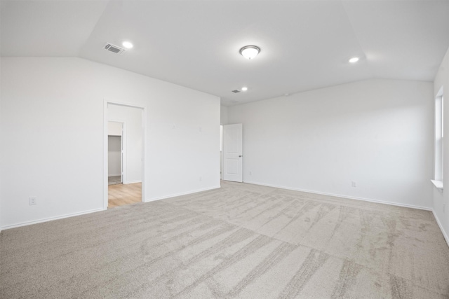 carpeted empty room with lofted ceiling