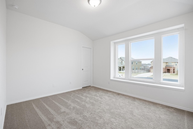 spare room featuring lofted ceiling and carpet flooring