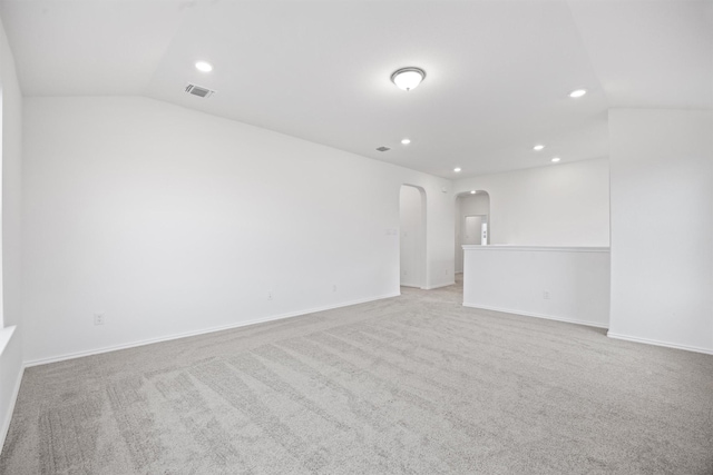 empty room featuring lofted ceiling and light colored carpet