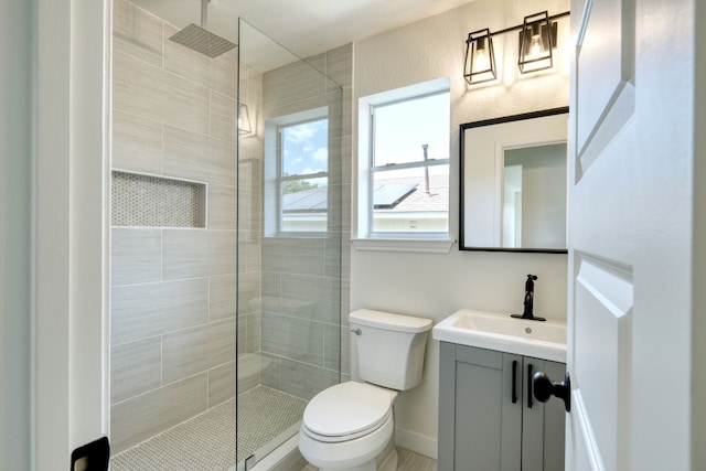 bathroom featuring vanity, walk in shower, and toilet