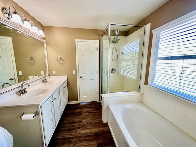 bathroom featuring vanity, hardwood / wood-style flooring, and plus walk in shower