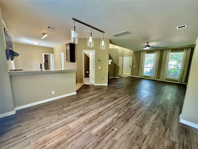 unfurnished living room featuring ceiling fan and dark hardwood / wood-style flooring