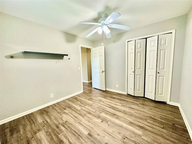 unfurnished bedroom featuring ceiling fan, a closet, and light wood-type flooring