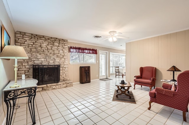 living room with crown molding, a fireplace, and light tile patterned floors