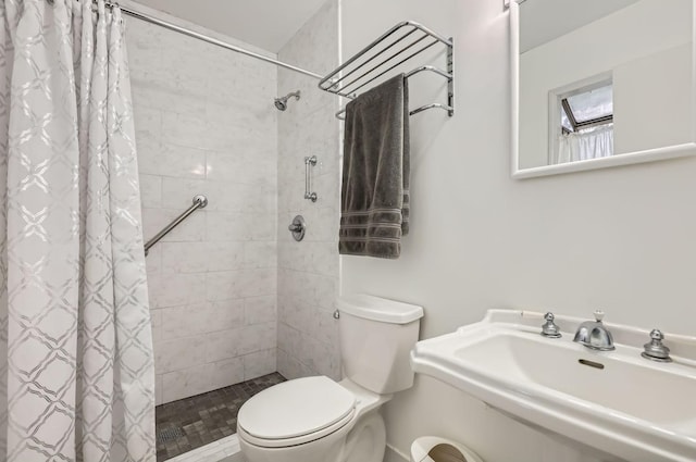 bathroom with sink, curtained shower, and toilet