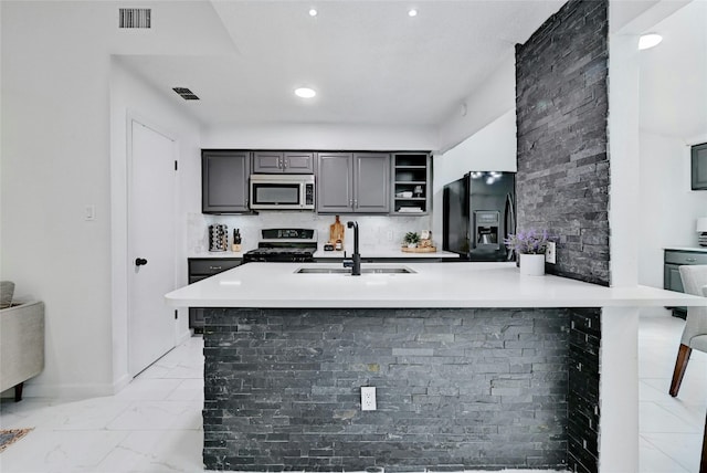 kitchen with stainless steel appliances, light countertops, visible vents, and open shelves