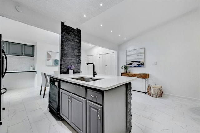 kitchen featuring an island with sink, marble finish floor, light countertops, and a sink