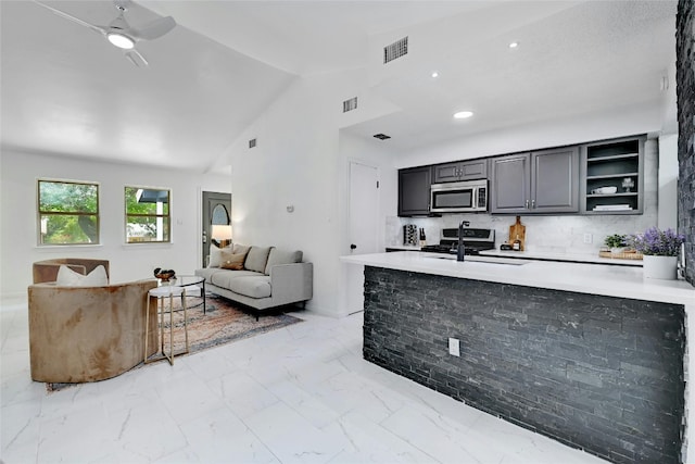 kitchen with stainless steel appliances, open floor plan, light countertops, marble finish floor, and open shelves