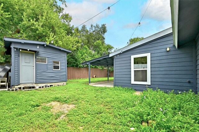 view of yard featuring a storage shed, an outdoor structure, and fence