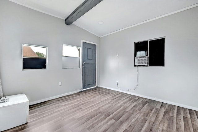 empty room with vaulted ceiling with beams, light wood finished floors, cooling unit, and baseboards