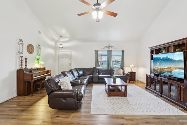 living room featuring light hardwood / wood-style flooring, high vaulted ceiling, and ceiling fan