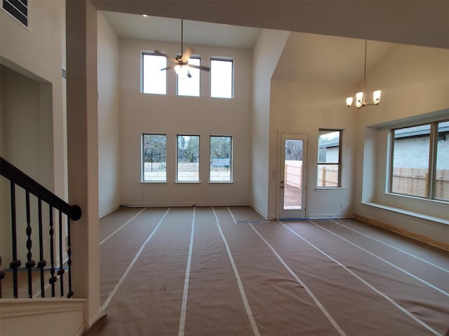 interior space with plenty of natural light, a towering ceiling, and a notable chandelier