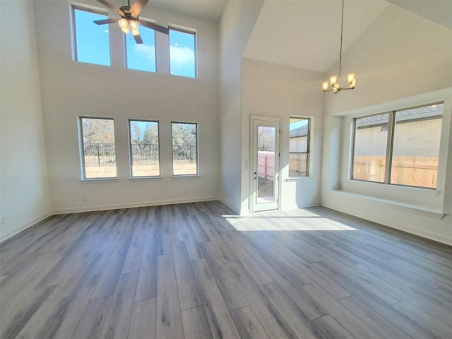 unfurnished living room featuring baseboards, a healthy amount of sunlight, and light wood finished floors