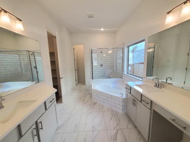 full bathroom with marble finish floor, a stall shower, two vanities, and a sink