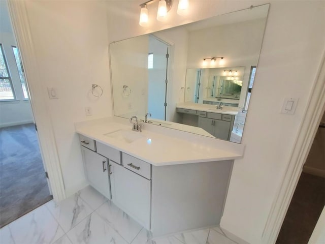 bathroom with marble finish floor and vanity