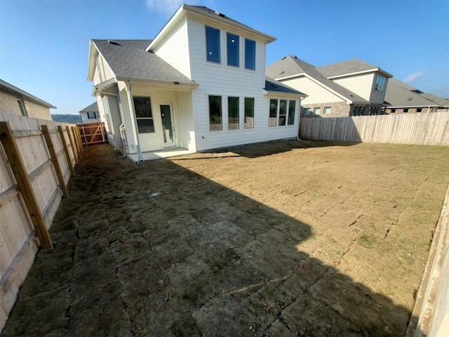 rear view of property featuring a fenced backyard