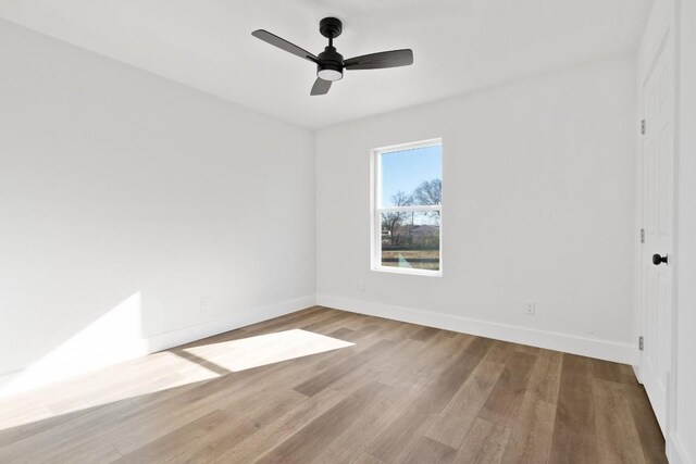 spare room with hardwood / wood-style floors and ceiling fan