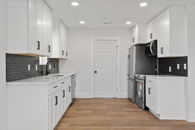 kitchen featuring white cabinetry, stainless steel appliances, light hardwood / wood-style floors, and sink