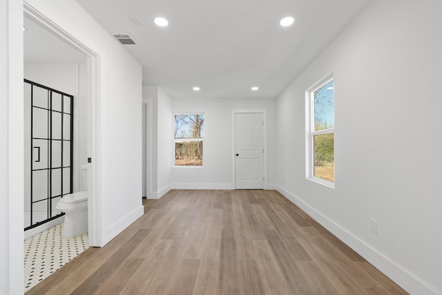 corridor with light hardwood / wood-style floors