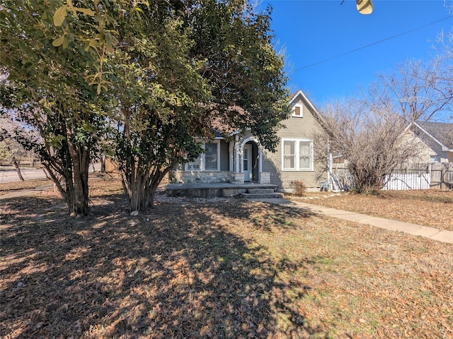 view of property hidden behind natural elements featuring a front lawn